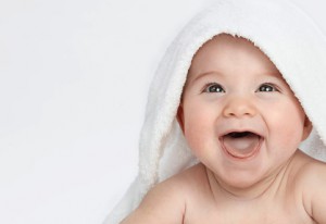 little child baby smiling lying under thr towel